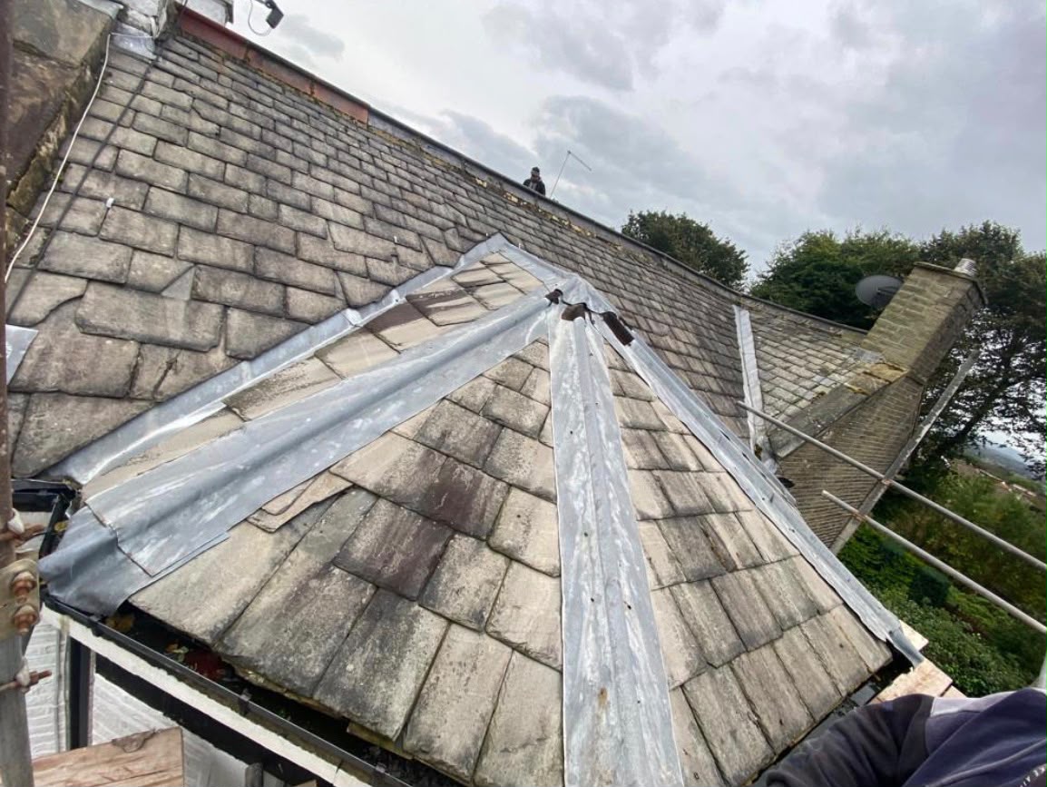 Traditional stone slate roof repaired with new lead valleys