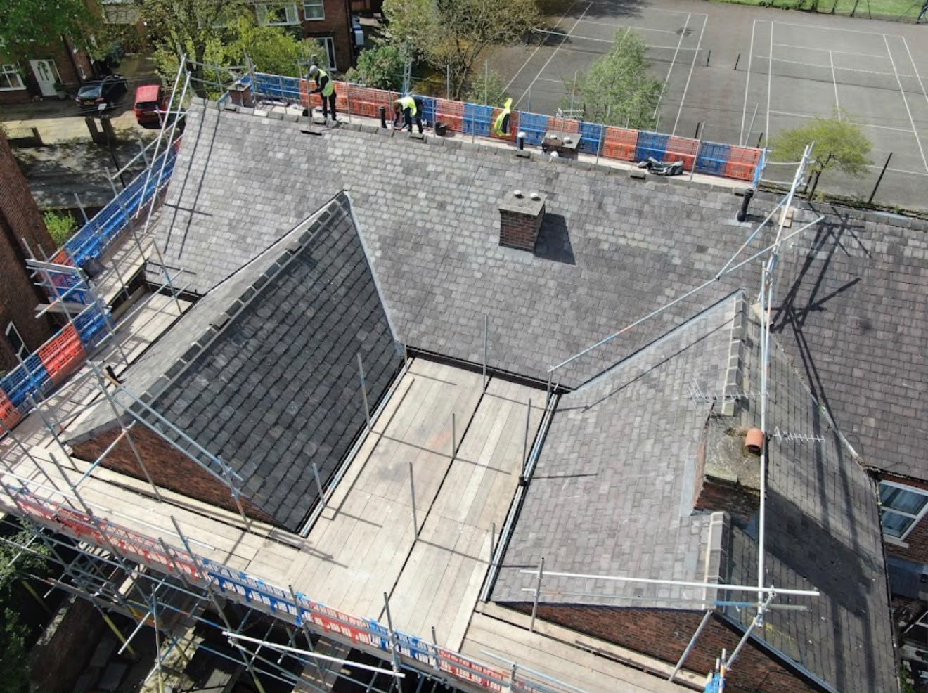 Aerial view of a large slate re-roof in progress with scaffolding