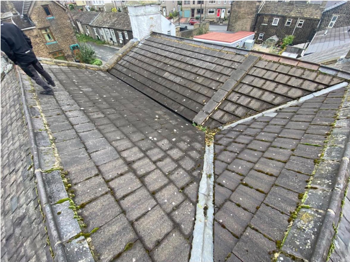 Weathered mossy slate roof photographed during a pre-repair inspection